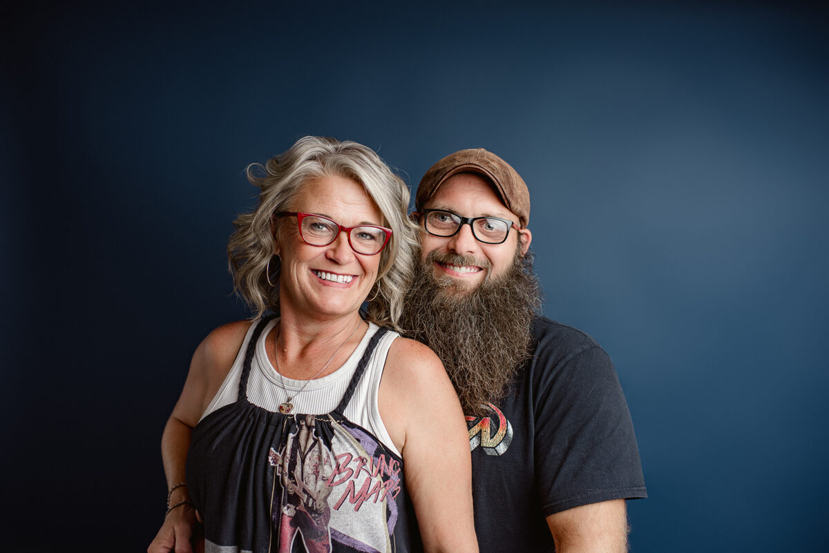 The owners of Blind Guy Records smiling together and holding vinyl records