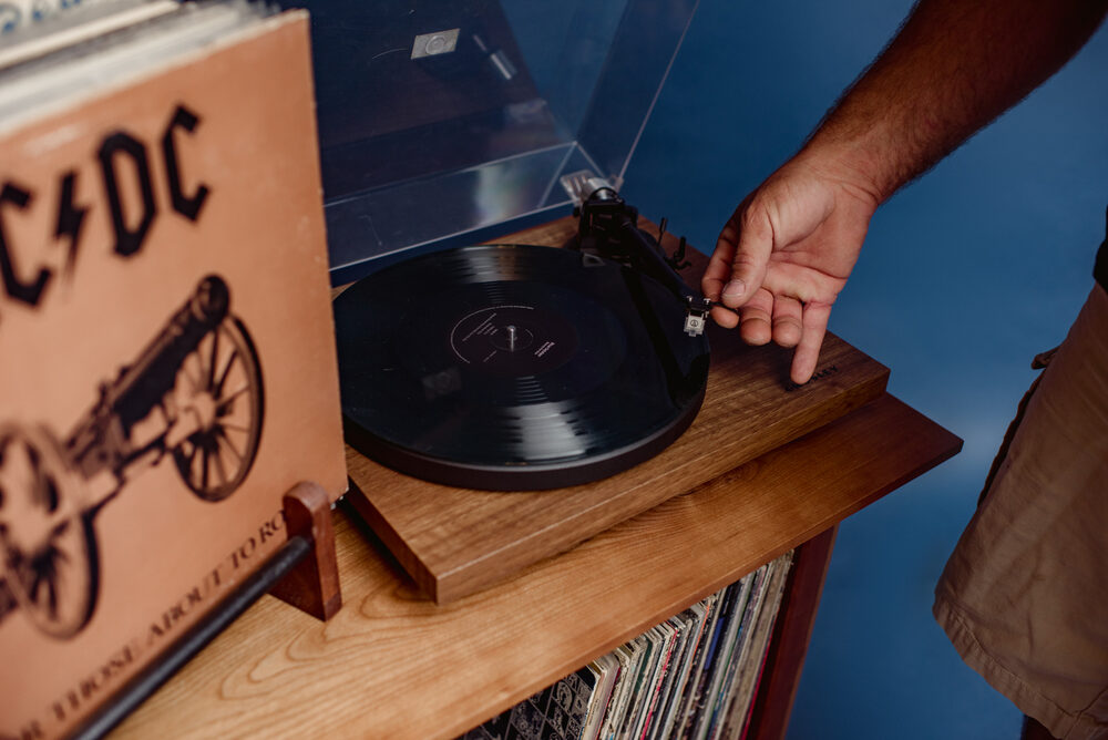 A vinyl record spinning on a turntable beside an AC/DC record sleeve